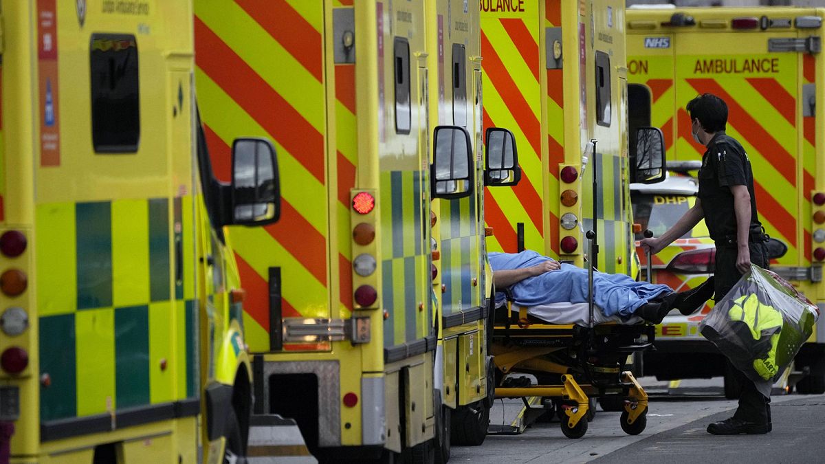 A patient is pushed on a trolley after arriving in an ambulance outside the Royal London Hospital in the Whitechapel area of east London