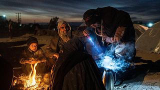 A family prepares tea outside the Directorate of Disaster office where they are camped, in Herat, Afghanistan, on Nov. 29, 2021.