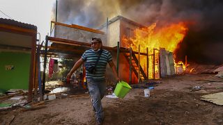 Un vecino ayuda a apagar el incendio de Laguna Verde, en la ciudad chilena de Iquique, el lunes 10 de enero