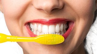 A woman brushes her teeth 