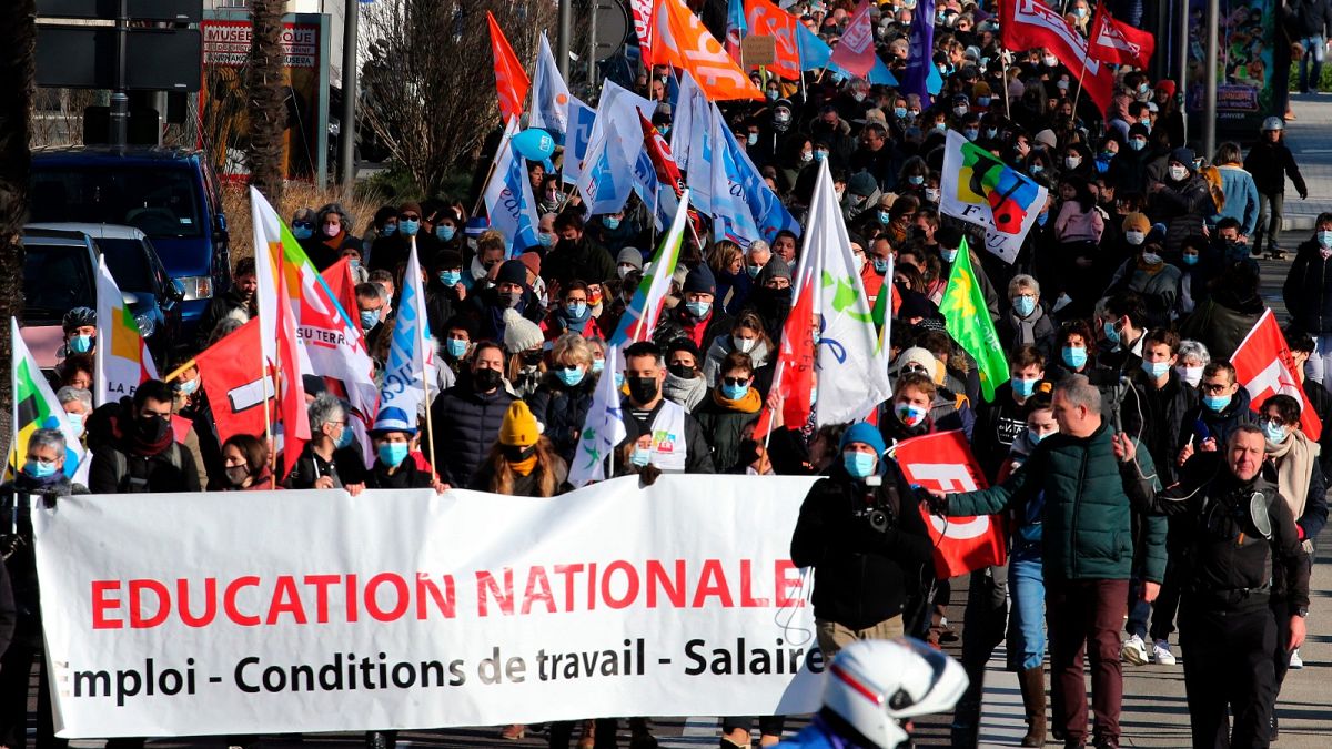 Teachers and students hold a banner reading " National Education- working condition - wages " as they demonstrate in Bayonne, southwestern France