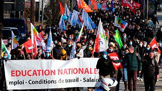 Teachers and students hold a banner reading " National Education- working condition - wages " as they demonstrate in Bayonne, southwestern France