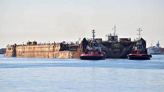 Vontatóhajók húzzák a Costa Concordia roncsát a genovai kikötőben 2016. szeptember elsején
