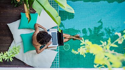 A woman works by a swimming pool A woman works by a swimming pool