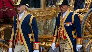 Footmen walk alongside the Golden Carriage as Netherlands' King Willem-Alexander and Queen Maxima arrive at Noordeinde Palace in 2013.