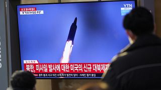 People watch a TV screen showing a news program reporting about North Korea's missile launch with a file image, at a train station in Seoul, South Korea, Jan. 14, 2022.