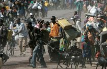 Straßenszene in Goma. Viele Menschen schleppen Wasserkanister