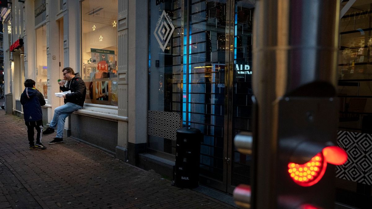 FILE- Closed restaurants because of a lockdown forced people to eat outdoors next to a closed shop in Amsterdam, Netherlands.