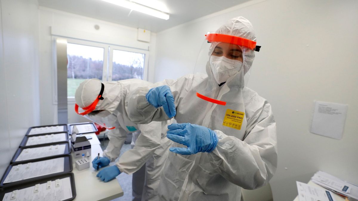 FILE- Medical workers examine the rapid antigen tests for the coronavirus in Prague, Czech Republic, Wednesday, Dec. 16, 2020. 