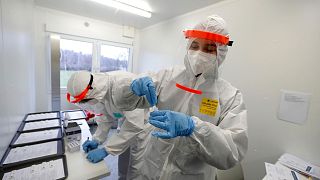FILE- Medical workers examine the rapid antigen tests for the coronavirus in Prague, Czech Republic, Wednesday, Dec. 16, 2020.