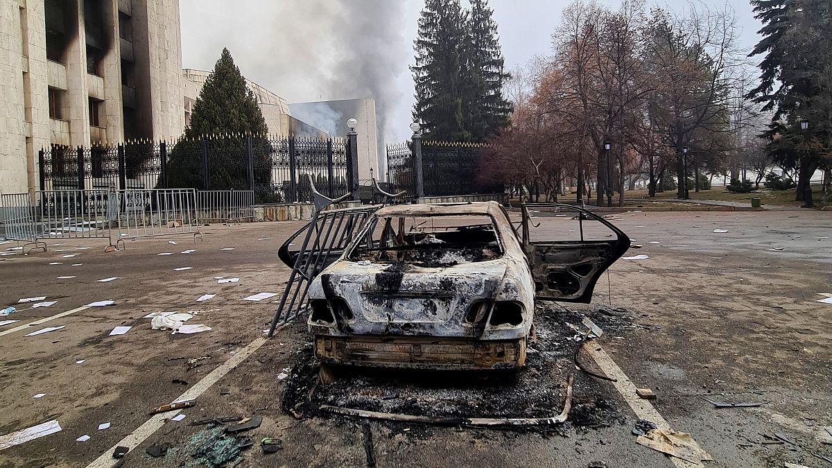 سيارة محترقة أمام مبنى البلدية في مدينة ألماتي في كازاخستان
