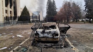 سيارة محترقة أمام مبنى البلدية في مدينة ألماتي في كازاخستان