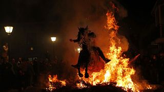 Ein Mann springt bein den Luminares mit seinem Pferd durch ein Lagerfeuer zu Ehren des Heiligen Antonius (in San Bartolome de Pinares, 2018)