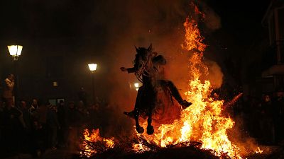 Ein Mann springt bein den Luminares mit seinem Pferd durch ein Lagerfeuer zu Ehren des Heiligen Antonius (in San Bartolome de Pinares, 2018)  