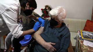 ممرّضة تقدّم جرعة ثانية من لقاح فايزر لمسنّة تجاوزت الـ 90 من عمرها، في منزلها بأثينا، الأربعاء ، 22 ديسمبر، 2021