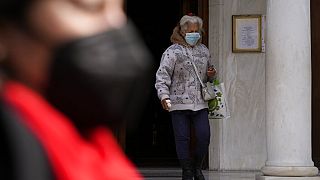Γυναίκα με μάσκα έξω από εκκλησία στην Αθήνα