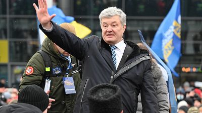 Ukraine's former leader Petro Poroshenko waves during a rally outside the airport upon his arrival in Kyiv.