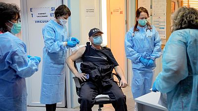 In this photo taken on Friday, Jan. 15, 2021 a Romanian gendarme gets a COVID-19 vaccine at a hospital in Bucharest, Romania.
