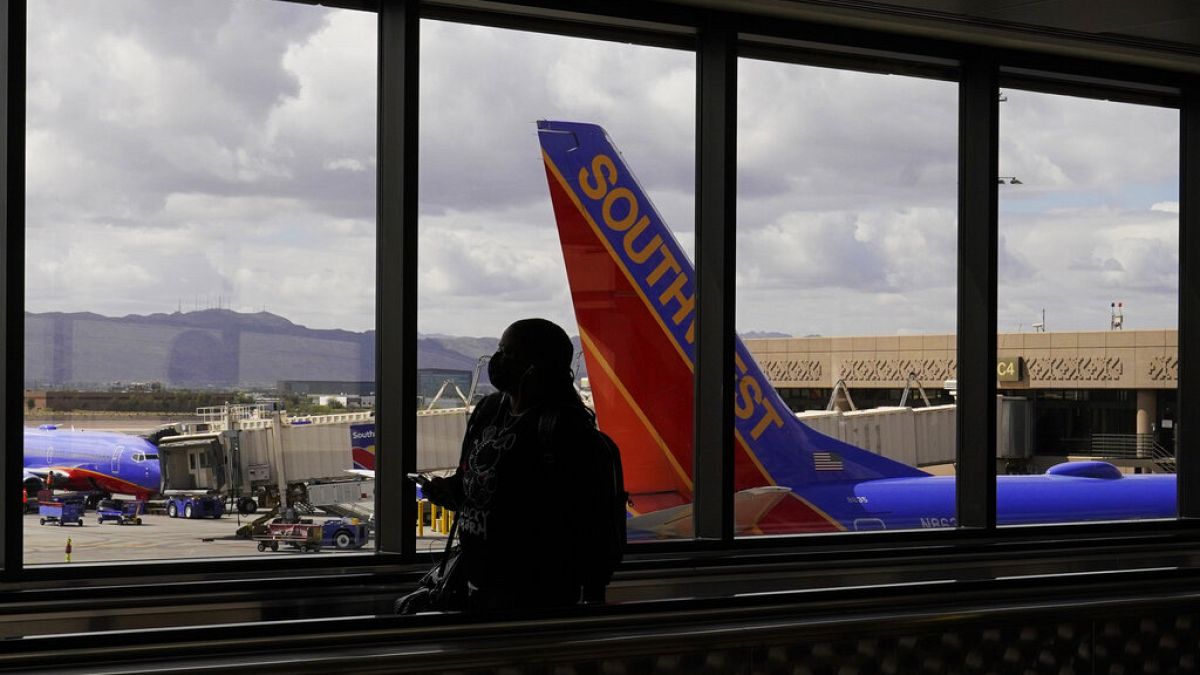 Un pasajero pasa por delante de un avión de Southwest Airlines en el aeropuerto internacional Sky Harbor de Phoenix, el 26 de marzo de 2021