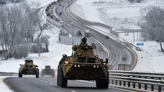 A convoy of Russian armored vehicles moves along a highway in Crimea, Tuesday, Jan. 18, 2022.