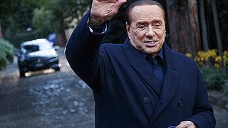 El ex primer ministro italiano Silvio Berlusconi saluda a los medios de comunicación tras una reunión con dirigentes de centro-derecha en Roma en diciembre de 2021