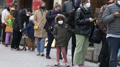 FILE - People wait in line outside a COVID-19 walk-in testing site, 5 December 2021, in Cambridge, Massachusetts, US. FILE - People wait in line outside a COVID-19 walk-in testing site, 5 December 2021, in Cambridge, Massachusetts, US.