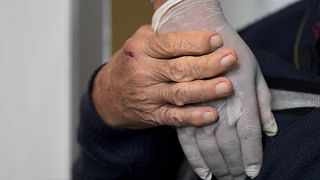 صورة رمزية لعجوز يمسك يد ممرضة في أحد مستشفيات كولومبيا