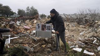  فلسطيني يحمل صوراً عائلية على أنقاض منزل هدمته بلدية القدس، في حي الشيخ جراح بالقدس الشرقية، 19 يناير، 2022