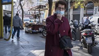 امرأة مسنة ترتدي كمامة للحد من انتشار فيروس كورونا تمشي في وسط أثينا. 2022/01/17