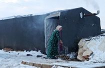 Une femme devant son abri de fortune dans un camp pour réfugiés d'Afrin (Syrie), le 19 janvier 2022