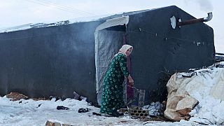Une femme devant son abri de fortune dans un camp pour réfugiés d'Afrin (Syrie), le 19 janvier 2022
