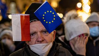 A man wearing a cap with flags of Poland and Eu takes part in a demonstration against a new rule voted in Polish parliament pointed against freedom of media