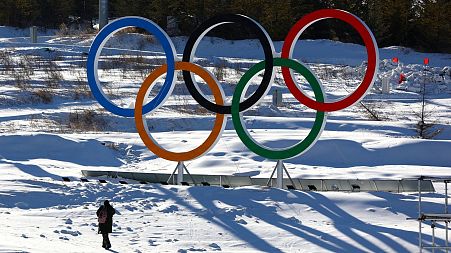A person walks past the Olympic rings in the Zhangjiakou competition zone ahead of the Beijing 2022 Winter Olympics in Beijing, China 
