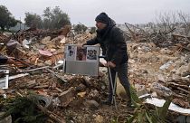 A Palestinian man carries family photos at the ruins of a house demolished by the Jerusalem municipality, in the East Jerusalem neighborhood of Sheikh Jarrah, on Jan. 19, 2022