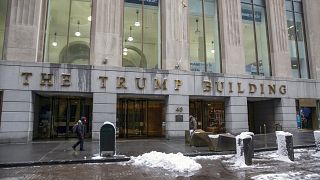 People walk by The Trump Building office building at 40 Wall Street in New York on Friday, Jan. 7, 2022.
