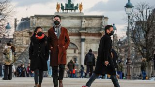 أشخاص يرتدون كمامات ويسيرون في حديقة التويلري بباريس يوم 5 يناير كانون الثاني 2022.