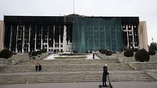 Municipal workers cover the burned city hall for repairs in Almaty.