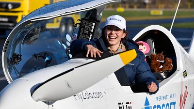 Belgium-British teenage pilot Zara Rutherford smiles as she gets out of the cockpit after landing her Shark ultralight plane