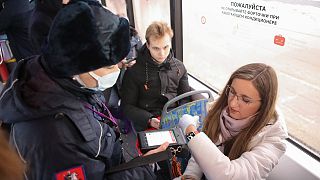 A controller checks a QR code and observance of the mask regime in public transport in Moscow