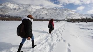 شخصان يسيران على الثلج بريف دمشق، سوريا، الجمعة 21 كانون الثاني 2022.