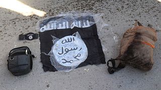 The flag and bags of Islamic State group fighters who were arrested by the Kurdish-led Syrian Democratic Forces after they attacked Gweiran Prison in Hassakeh
