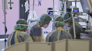 طاقم طبي في مستشفى سانا كلينيكوم أوفنباخ في ألمانيا يعتنون بمريض في وحدة العناية المركزة لمرضى كورونا