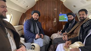 Taliban senior official member Anas Haqqani (R) and delegates sitting on a plane before departing to Oslo, at the Kabul airport in Kabul.