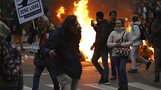 Manifestants à proximité d'un pneu enflammé, lors d'une manifestation contre les restrictions liées au Covid-19 - Bruxelles (Belgique), le 23/01/2022