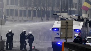 Police set off a water cannon against protestors during a demonstration against COVID-19 measures in Brussels, Sunday, Jan. 23, 2022