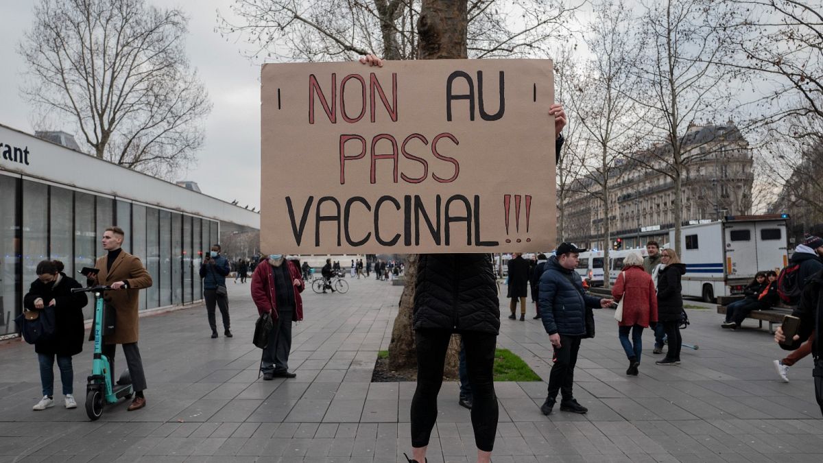 A demonstrator holds a sign that reads 'No to vaccine pass' in opposition to the new vaccine pass during a rally in Paris, France, on 22 January 2022.