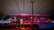 Projectors light the sky during The Contemporary Myth of Kaunas Trilogy, "The Confusion", near Zalgirio Arena in Kaunas, Lithuania, Jan. 22, 2022.