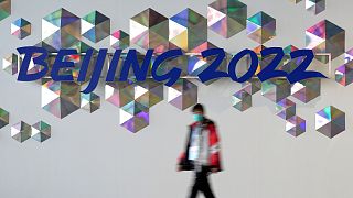 A person walks past a Beijing 2022 sign inside the main media center at the 2022 Winter Olympics, Saturday, Jan. 22, 2022, in Beijing.