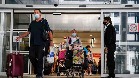 Passengers arrive at Gatwick Airport in London. This summer, no tests will be required from vaccinated travellers.