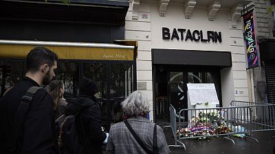 People pay their homage to the victims of the Nov.13, 2015 attacks in front of the entrance of the Bataclan after a ceremony marking the sixth anniversary in 2021.